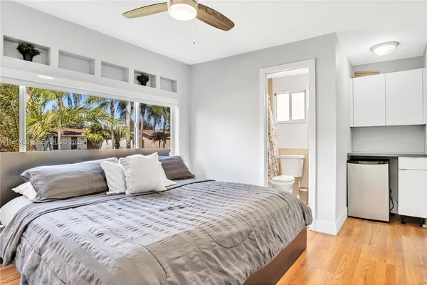 a bedroom with a large bed and a flat tv screen on dresser