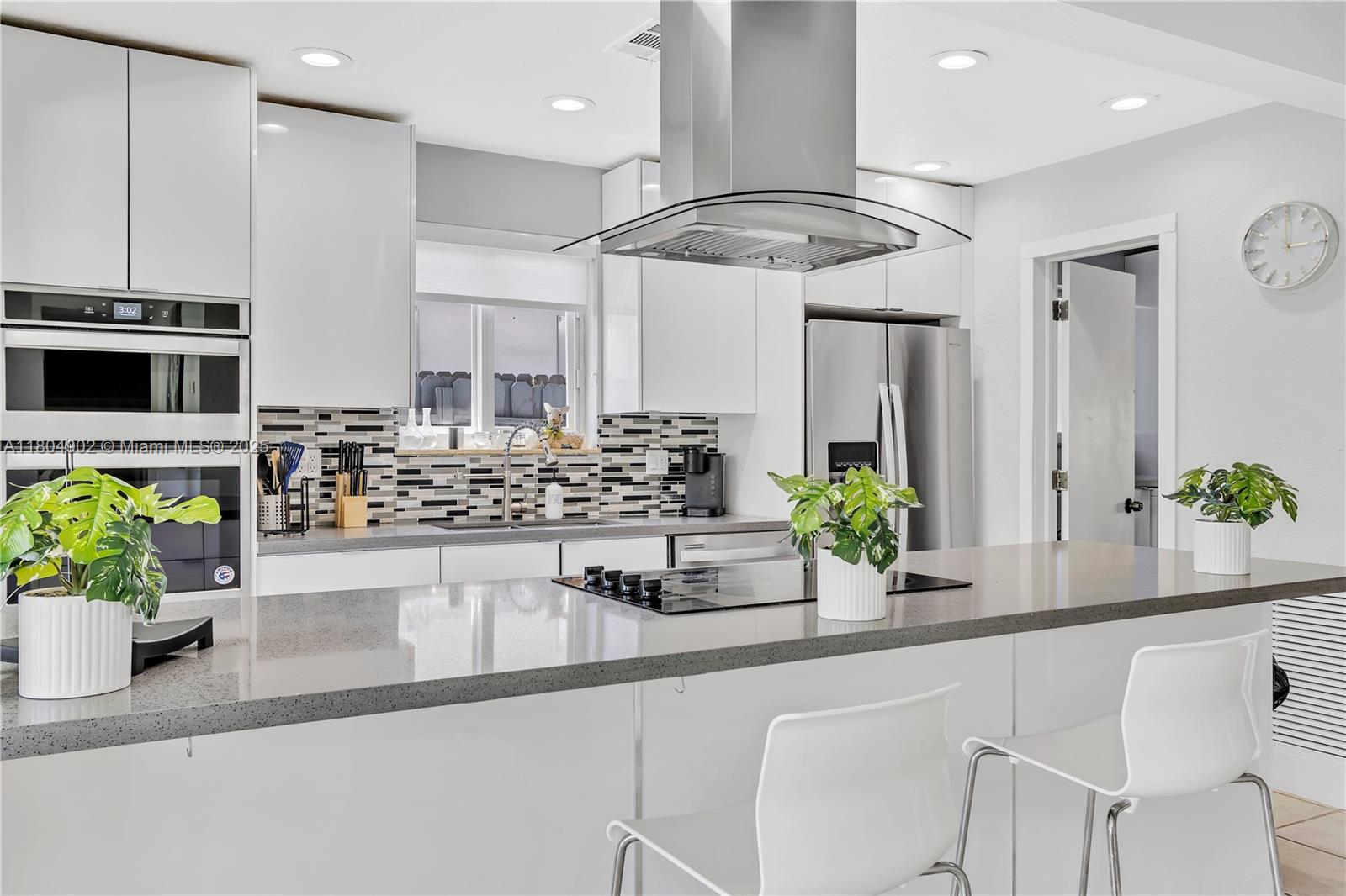 2828 Cleveland Street Hollywood, FL 33020 - Photo 4 of 23 a kitchen with stainless steel appliances kitchen island granite countertop a sink a counter top space cabinets and wooden floor