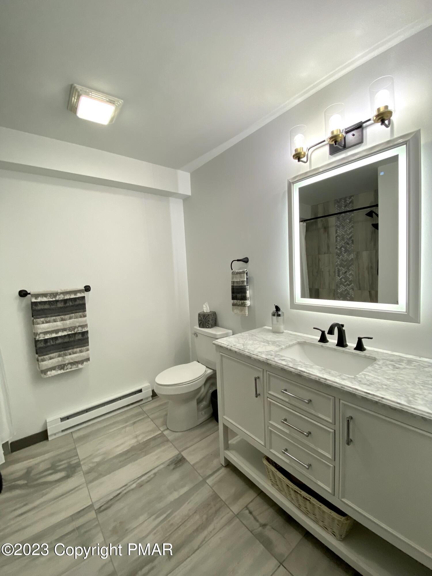6267 Laurel Road Pocono Summit, PA 18346 - Photo 11 of 27 a bathroom with a toilet sink and mirror