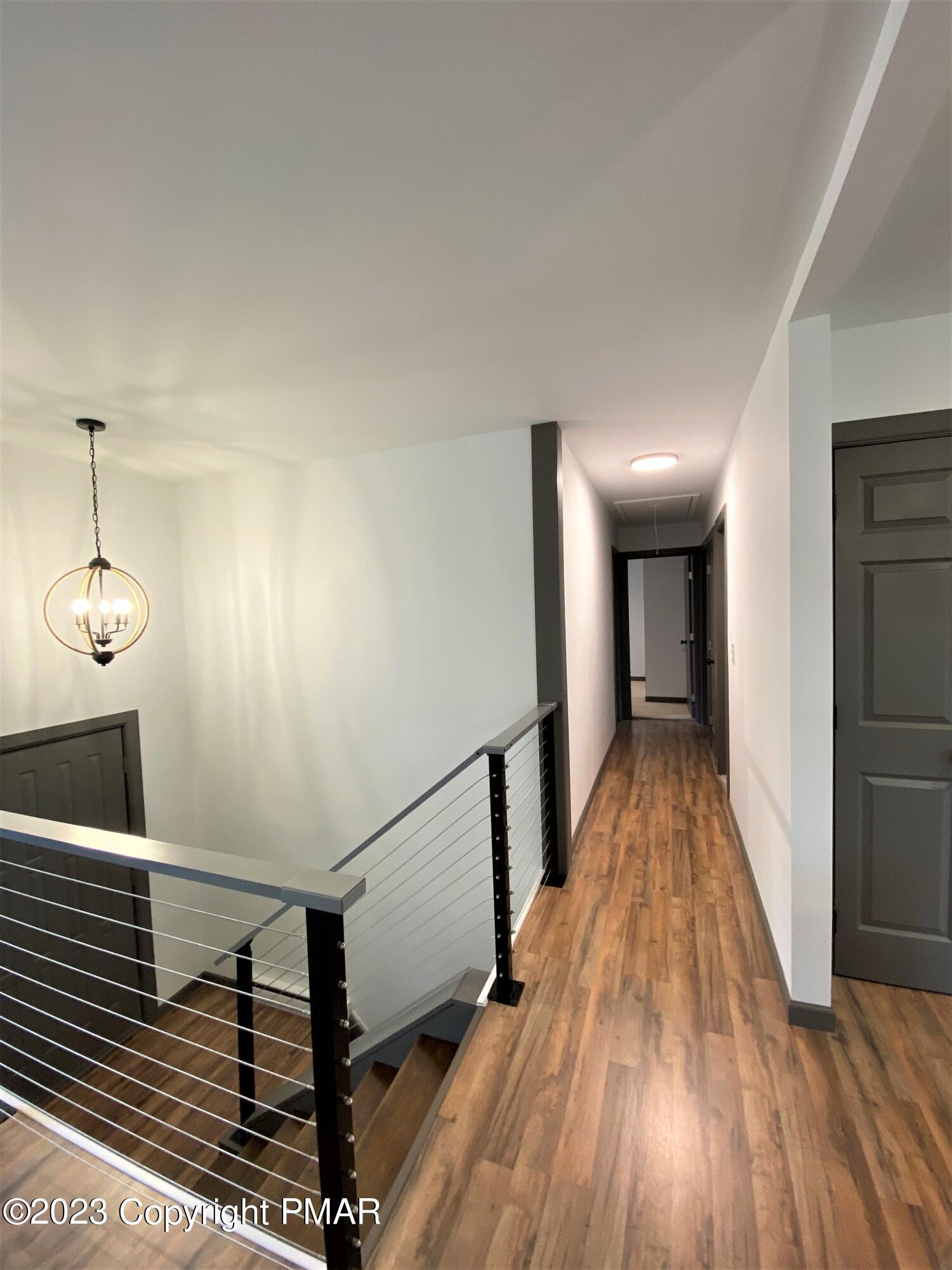 6267 Laurel Road Pocono Summit, PA 18346 - Photo 3 of 27 a view of a hallway with wooden floor and staircase