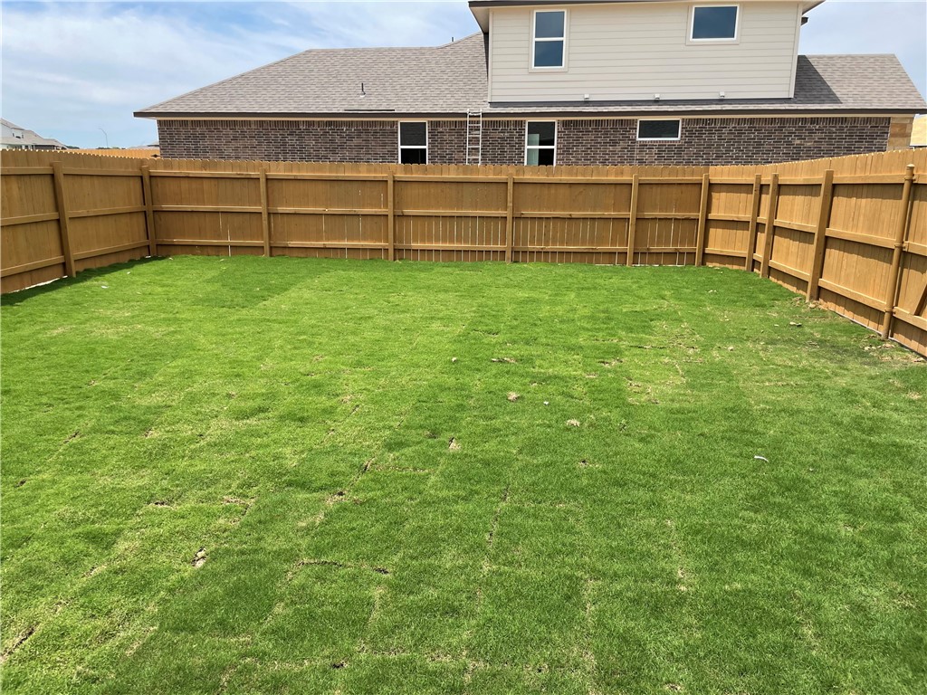 609 Paddock Lane Georgetown, TX 78626 - Photo 27 of 40 A spacious grassy lawn sits fully enclosed by a tall privacy fence.
