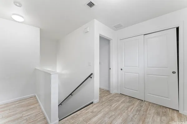 a view of an empty room with wooden floor