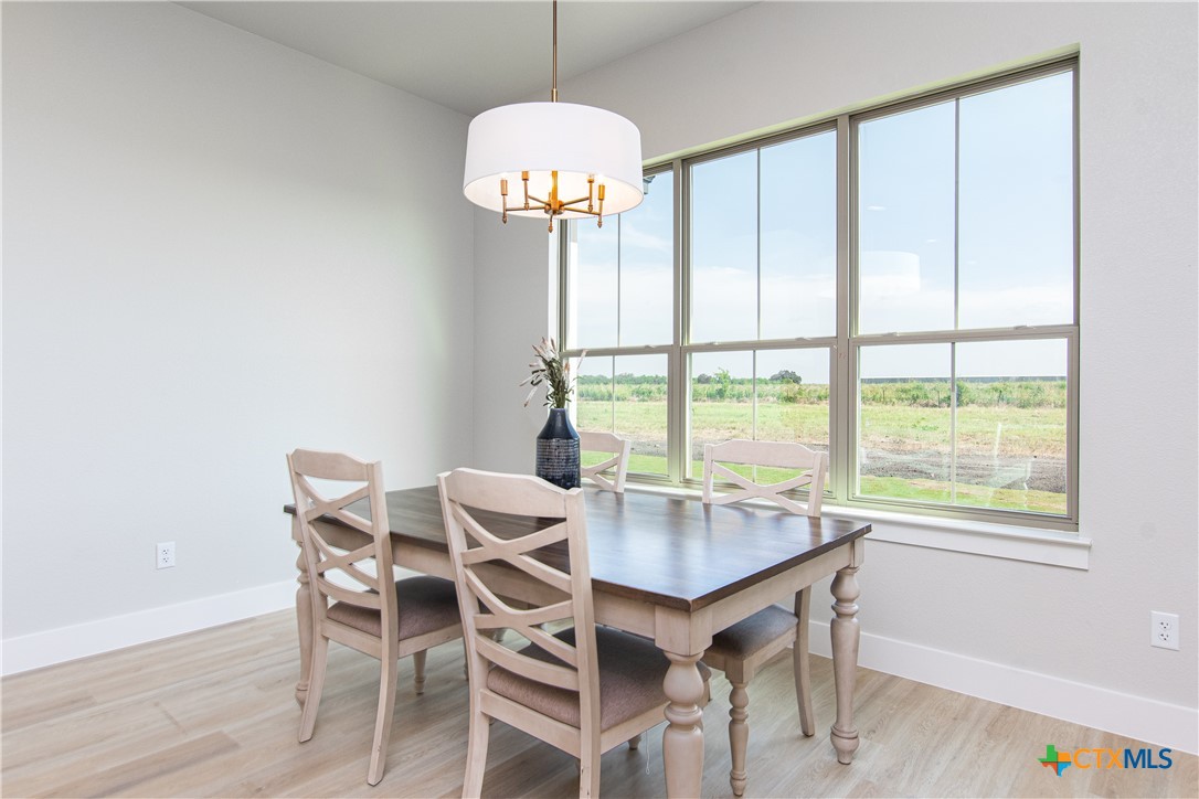8152 Evenfall Lane Temple, TX 76501 - Photo 12 of 33 a dining room with chandelier fan and wooden floor