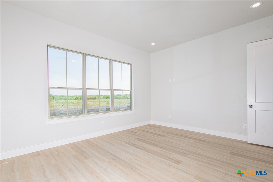 8152 Evenfall Lane Temple, TX 76501 - Photo 16 of 33 an empty room with wooden floor and windows