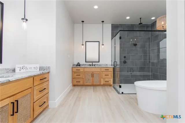 a bathroom with a double vanity sink a toilet a mirror and shower