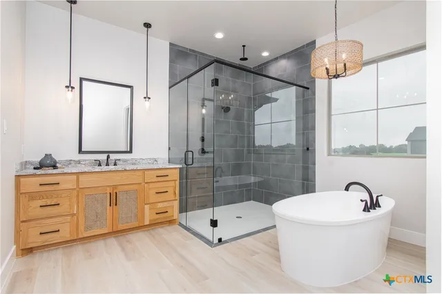 a bathroom with a double vanity sink a mirror a bathtub and shower