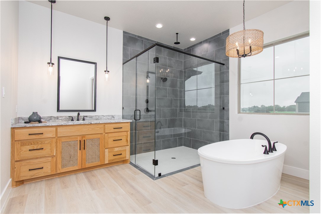 8152 Evenfall Lane Temple, TX 76501 - Photo 20 of 33 a bathroom with a double vanity sink a mirror a bathtub and shower