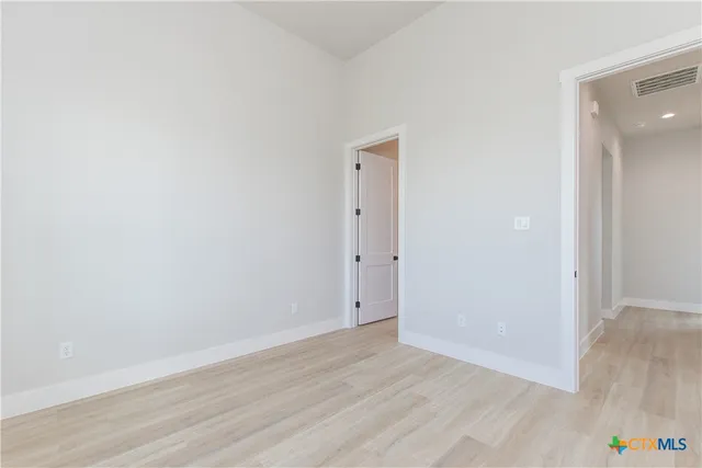 a view of an empty room with wooden floor