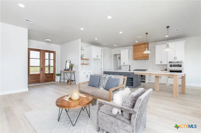 a living room with furniture and a view of kitchen