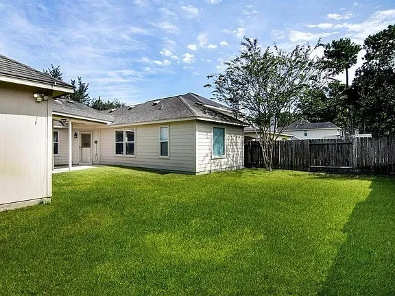 a front view of house with yard and trees in the background