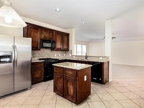a kitchen with stainless steel appliances granite countertop a stove a refrigerator and a sink