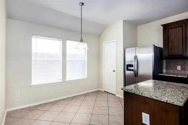 a kitchen with kitchen island granite countertop a sink a counter space appliances and cabinets