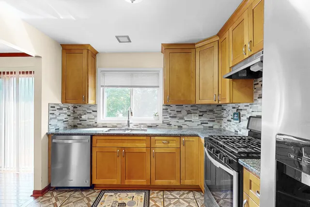 a kitchen with stainless steel appliances granite countertop a stove a sink and a microwave