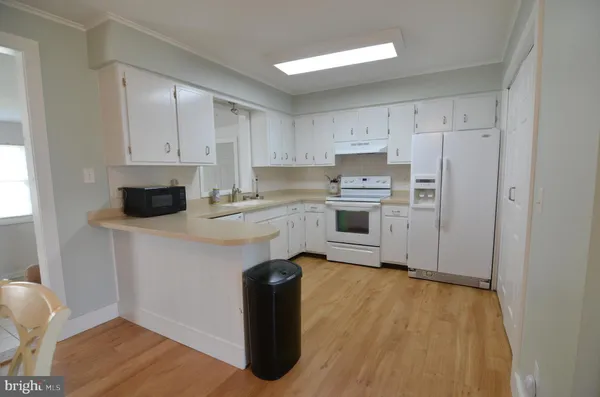 a kitchen with a refrigerator sink and cabinets