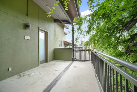 a view of balcony with wooden floor and iron fence