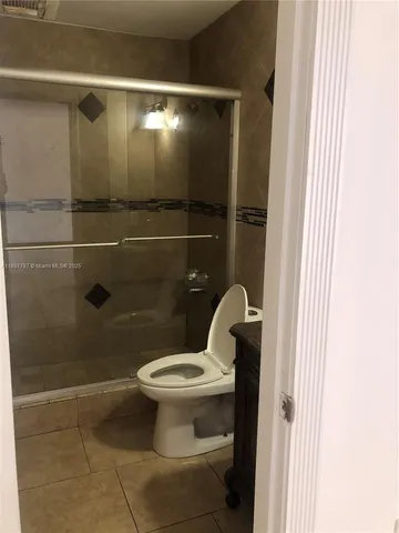 a bathroom with a toilet and a shower