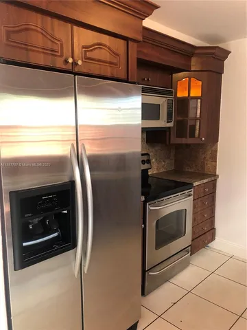 a kitchen with a refrigerator and cabinets