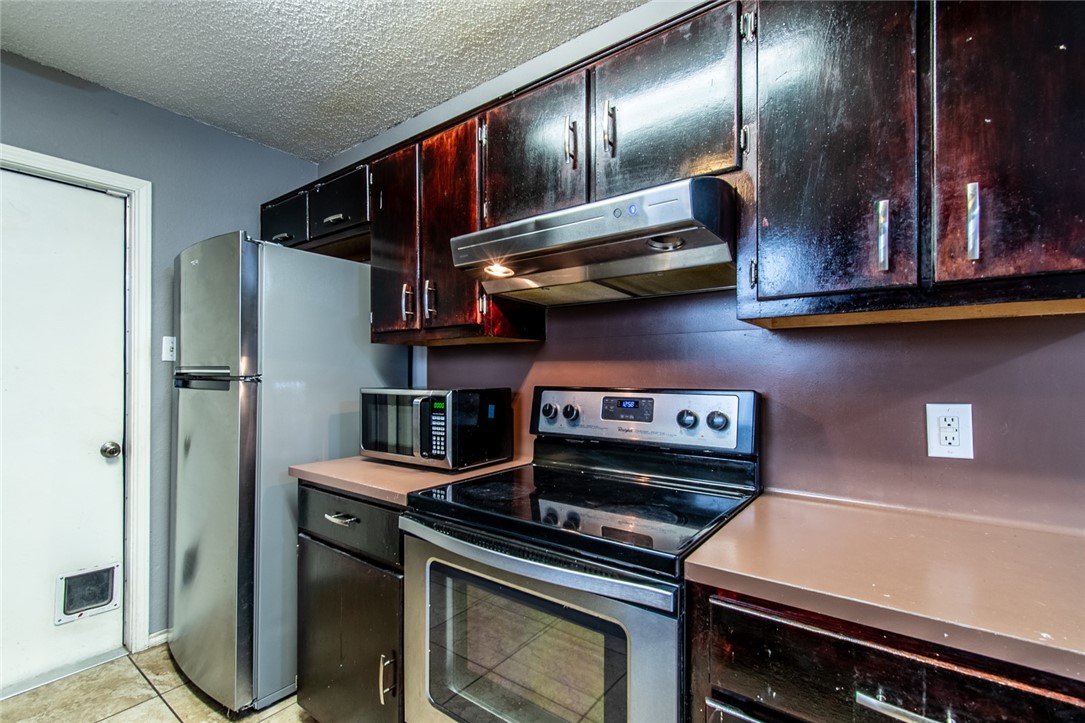 2185 Spring Park Drive Ingleside, TX 78362 - Photo 11 of 32 a kitchen with stainless steel appliances granite countertop a stove and a refrigerator