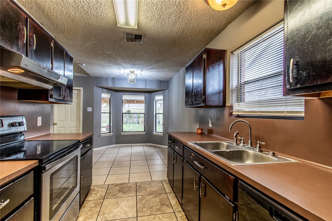 2185 Spring Park Drive Ingleside, TX 78362 - Photo 13 of 32 a kitchen with a sink and stove