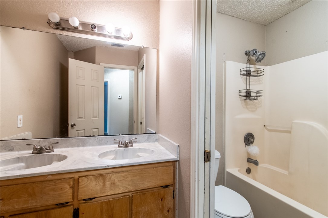 2185 Spring Park Drive Ingleside, TX 78362 - Photo 26 of 32 a bathroom with a granite countertop sink toilet and shower