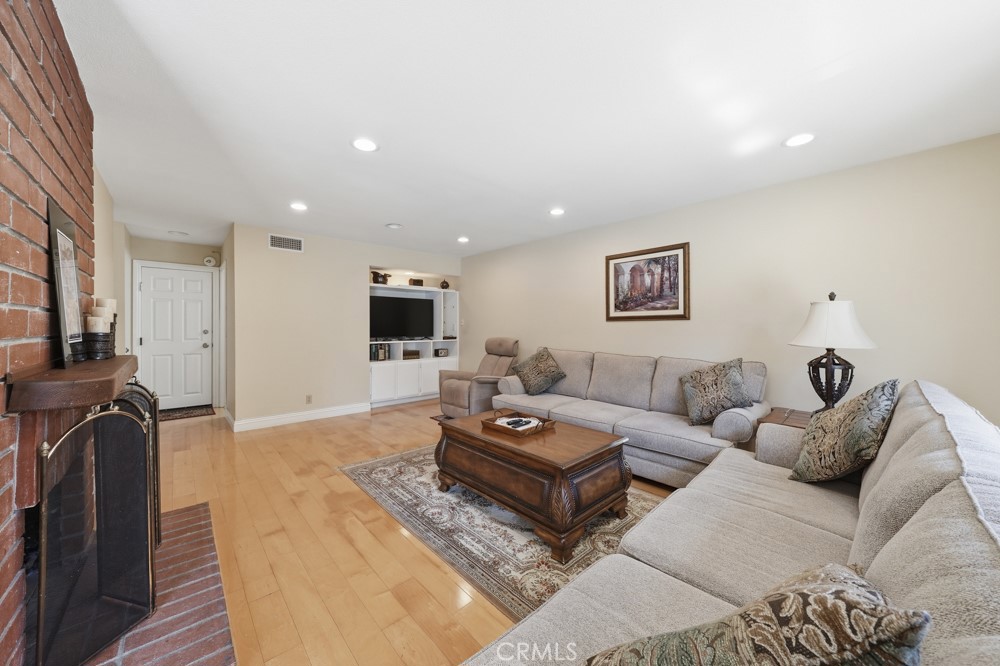 5 Eden Irvine, CA 92620 - Photo 14 of 42 a living room with furniture a flat screen tv and a fireplace