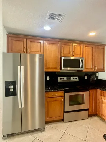 a kitchen with granite countertop a sink and white cabinets