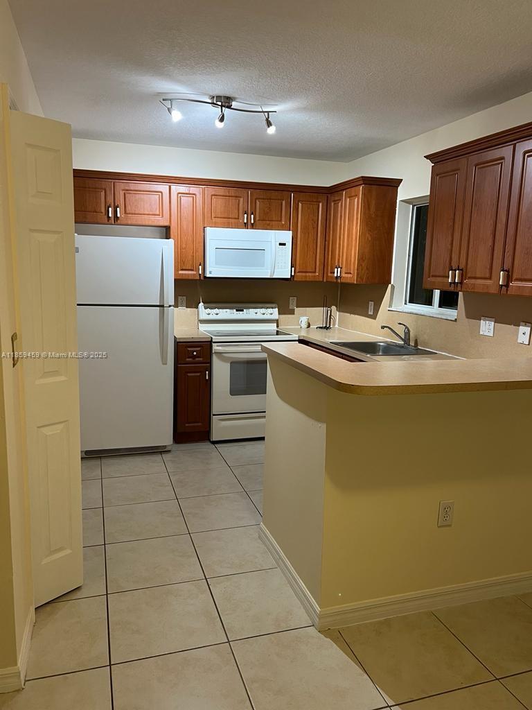 2701 Southeast 12th Road, Unit 101 Homestead, FL 33035 - Photo 3 of 5 a kitchen with stainless steel appliances granite countertop a sink counter space and cabinets