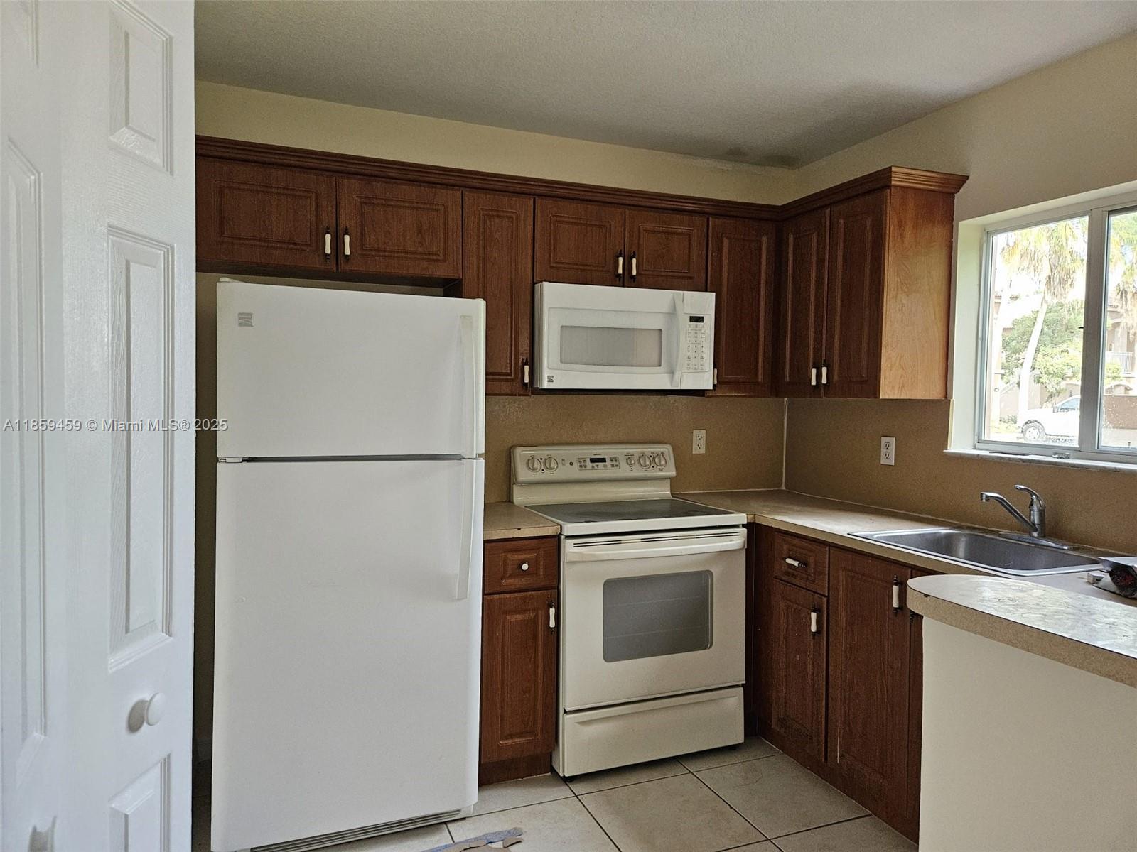 2701 Southeast 12th Road, Unit 101 Homestead, FL 33035 - Photo 4 of 5 a kitchen with a refrigerator sink and stove
