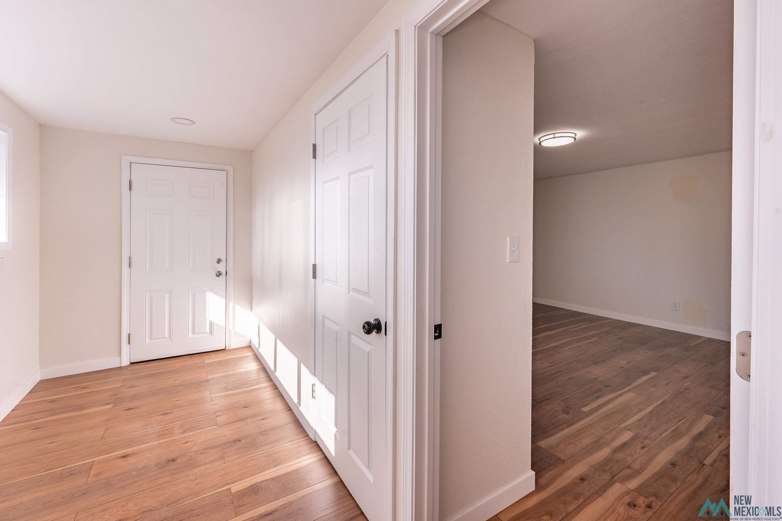 1131 Lincoln Avenue Raton, NM 87740 - Photo 23 of 41 Hallway featuring light wood-type flooring and baseboards