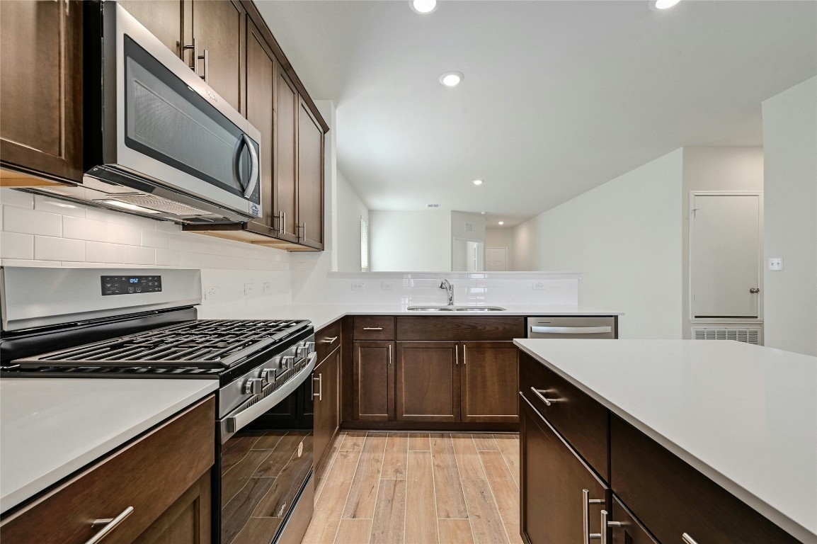 529 Tree Nut Loop Buda, TX 78610 - Photo 11 of 37 a kitchen with stainless steel appliances a sink stove and cabinets