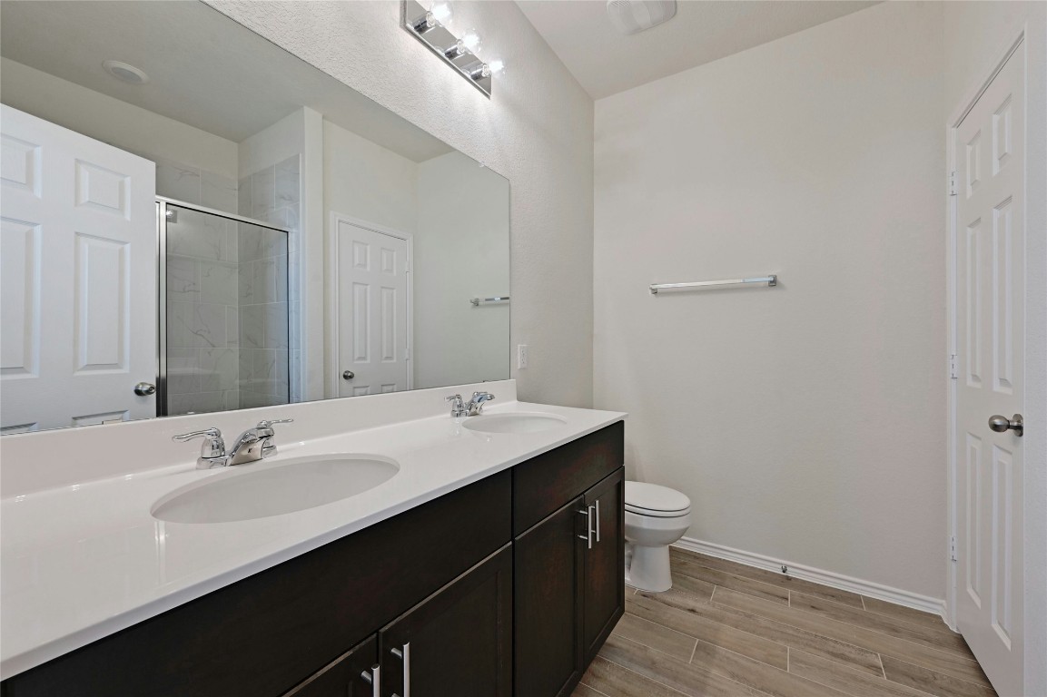 529 Tree Nut Loop Buda, TX 78610 - Photo 16 of 37 a bathroom with a sink a toilet and a mirror