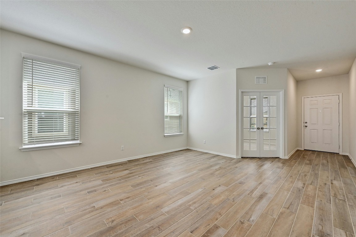 529 Tree Nut Loop Buda, TX 78610 - Photo 4 of 37 a view of an empty room with wooden floor and a window