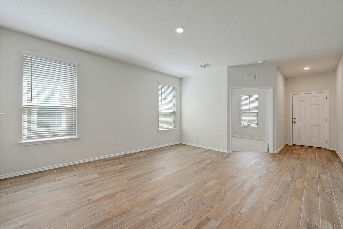 529 Tree Nut Loop Buda, TX 78610 - Photo 7 of 37 a view of an empty room with wooden floor and a window