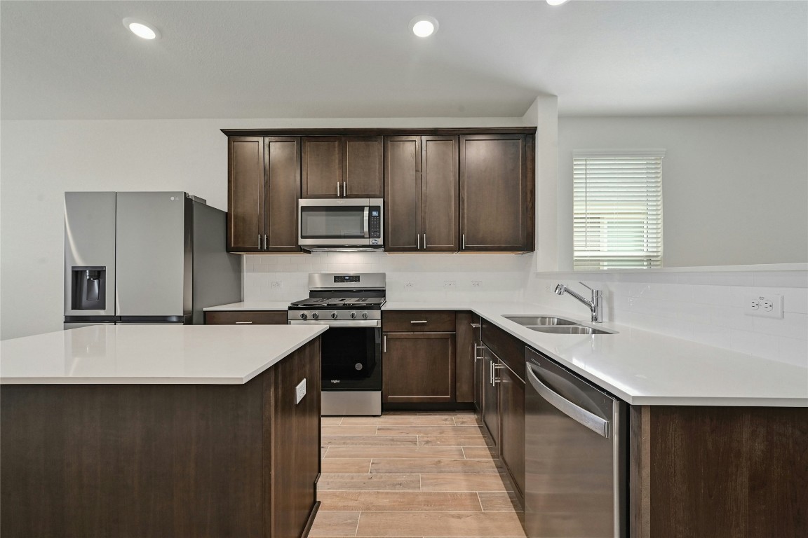 529 Tree Nut Loop Buda, TX 78610 - Photo 10 of 37 a kitchen with kitchen island a sink stove and refrigerator
