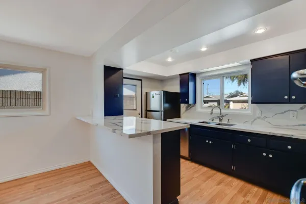 a kitchen with kitchen island granite countertop a sink and refrigerator