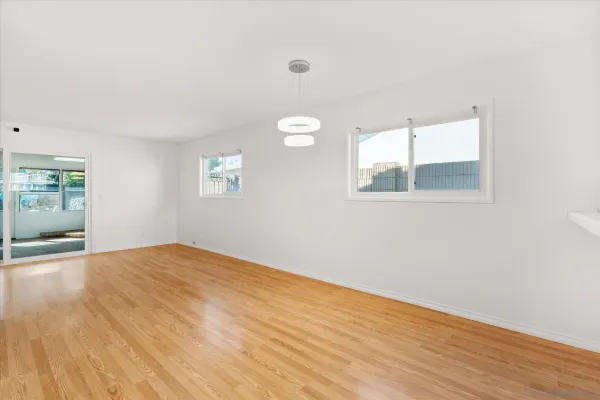a large kitchen with stainless steel appliances granite countertop a large counter top and a stove with wooden floor
