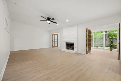 a view of an empty room with a fireplace and a window