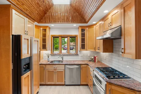 a kitchen that has a lot of cabinets in it and stainless steel appliances