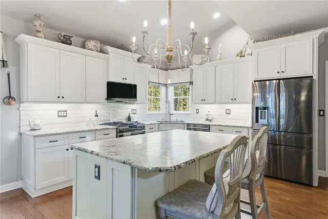 a kitchen with kitchen island appliances and cabinets