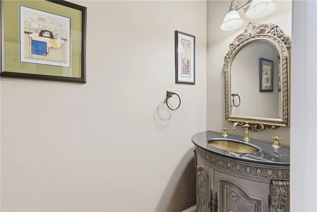 a bathroom with a granite countertop sink a mirror and vanity