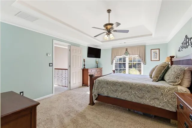 a bedroom with a bed a window and a flat screen tv