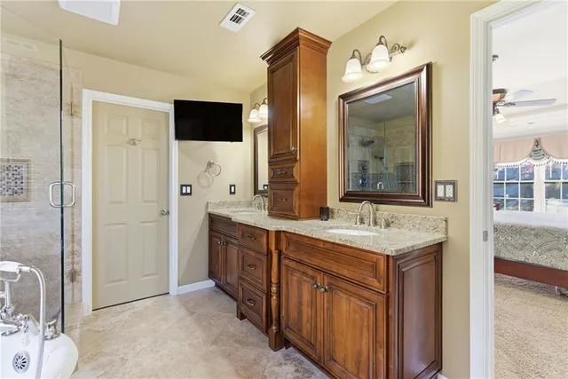 a bathroom with a double vanity sink mirror and shower