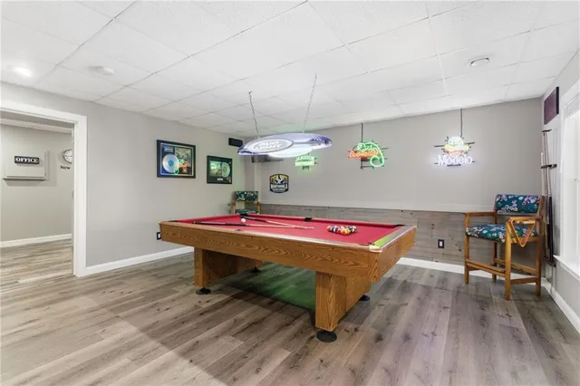 a room with pool table wooden floor and windows