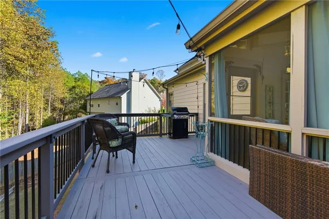 a view of a house with wooden deck and furniture