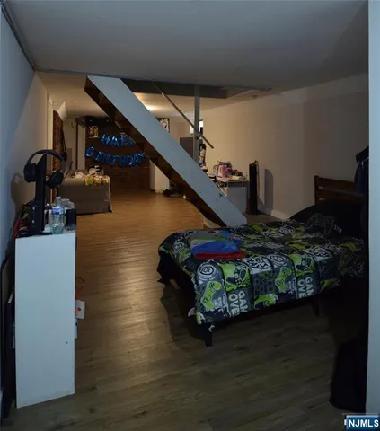 a room with lots of potted plants wooden floor and glass door
