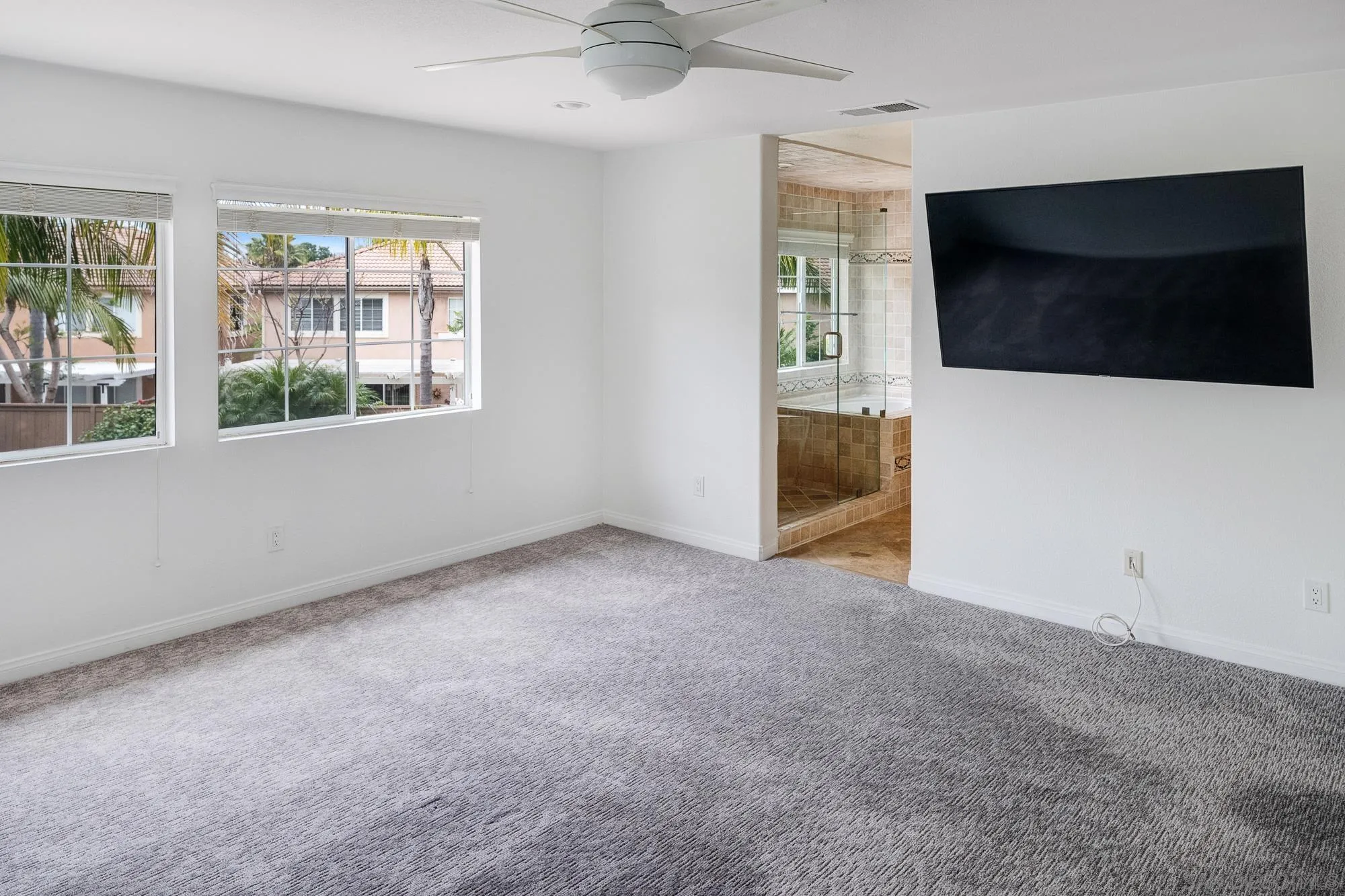 4318 Meadow Spring Way Oceanside, CA 92057 - Photo 28 of 50 an empty room with windows and a flat screen tv