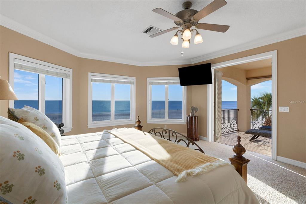 13423 Gulf Lane Madeira Beach, FL 33708 - Photo 31 of 71 a spacious bedroom with a large bed and a chandelier