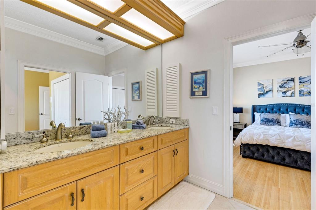 13423 Gulf Lane Madeira Beach, FL 33708 - Photo 50 of 71 a en suite bathroom with a double vanity sink and a mirror