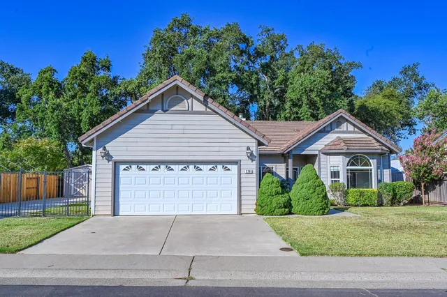 a front view of a house with a yard and a garage