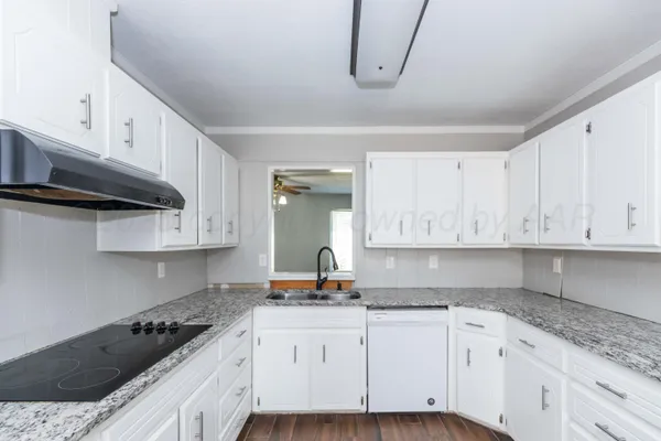 a kitchen with granite countertop white cabinets and stainless steel appliances